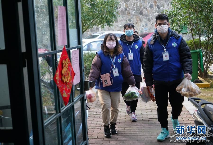 在南京市江宁区秣陵街道牛首社区一处小区,社区网格员陶慧(左)和王俊(中)等为居家隔离的居民送上代购的物品(2月5日摄)。 新华社记者 季春鹏 摄