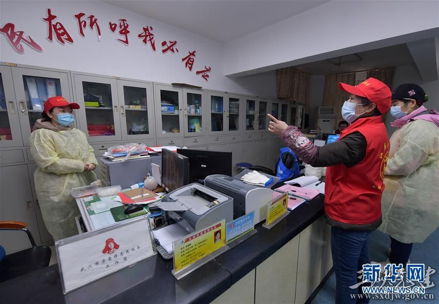 武汉市永清街道沈阳社区党委书记雷莉华(右二)在社区办公室为同事分配工作任务(2月12日摄)。 新华社记者 李贺 摄