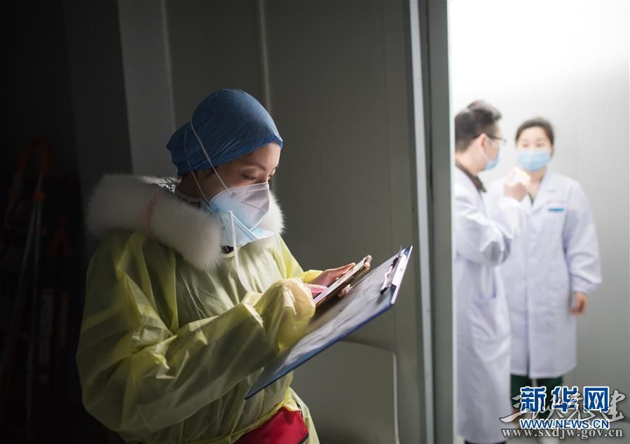 武汉市第一医院党员护士长孙纯(左)在武汉雷神山医院翻看患者医嘱情况(2月8日摄)。 新华社记者 肖艺九 摄