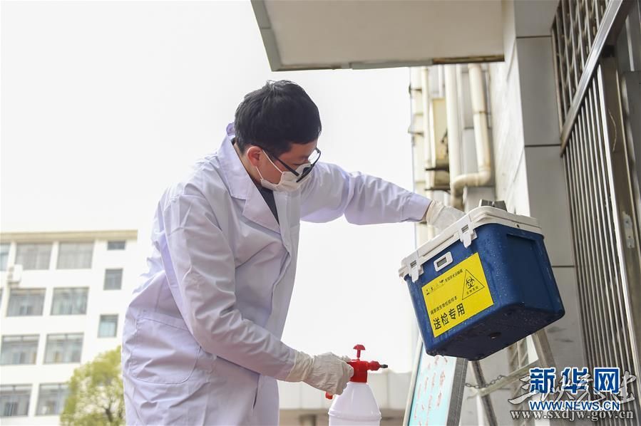 在湖北省孝感市疾控中心,工作人员李皓在对运送疑似样品的专用盒进行消毒处理(2月14日摄)。 新华社记者 胡虎虎 摄