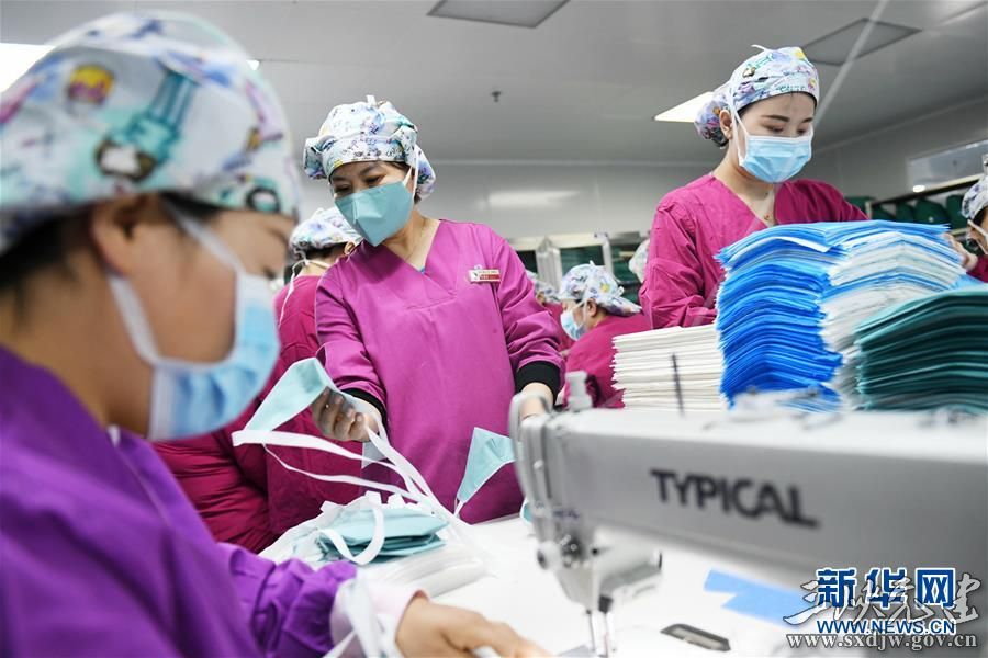 在西安交通大学第二附属医院消毒供应中心,消毒供应科主任司慧君(中)检查制作完成的口罩(2月7日摄)。 新华社记者 李一博 摄