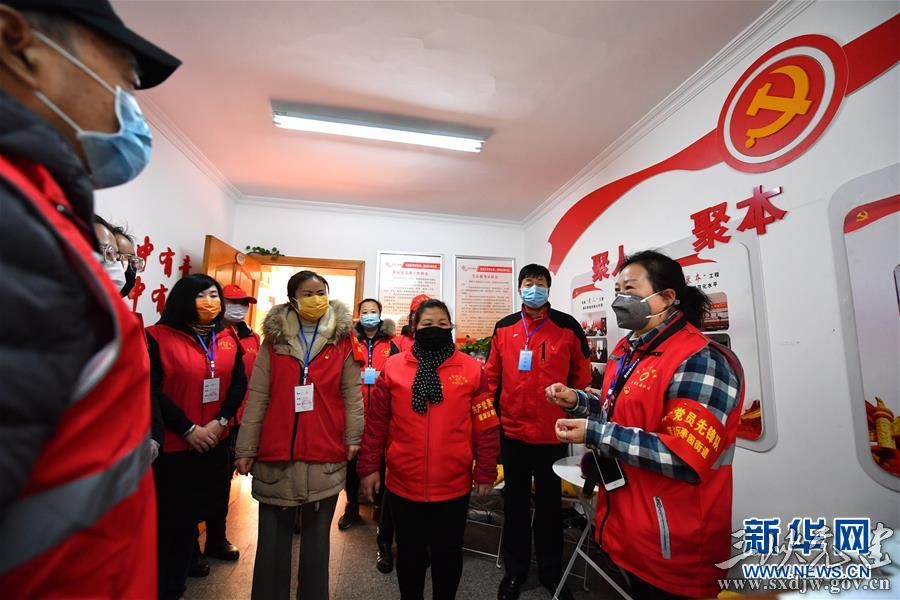 陕西省西安市莲湖区枣园街道唐都花园社区党支部书记姚美珍(右一)与工作人员和志愿者讨论当日分工安排(2月11日摄)。 新华社记者 张博文 摄